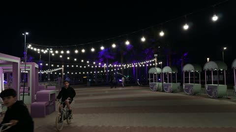 أطفال يركبون الدراجات في ساحة فعاليات بالظهران ليلاً