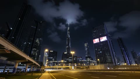 برج خليفة وأفق دبي ليلاً بحركة مرور سريعة