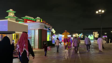 زوار يتجولون في مهرجان ليلي مع عروض ترفيهية