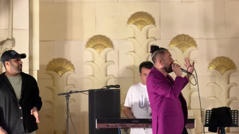 مغني يؤدي عرضاً حياً مع فرقة موسيقية على المسرح