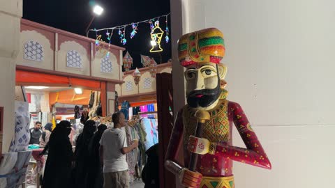تمثال تقليدي في سوق ليلي مزدحم بالمتسوقين
