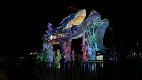 بوابة غلوبال سيتي المضيئة بنقوش بحرية ليلاً