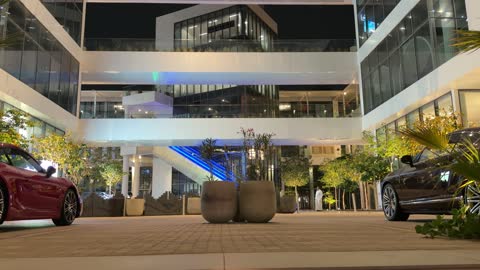 مجمع تجاري حديث مع سيارات فاخرة ليلاً