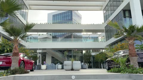 سيارات فاخرة أمام مبنى تجاري حديث في وضح النهار