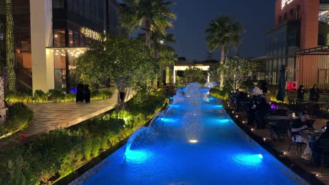 Modern Urban Outdoor Dining with Illuminated Fountain at Night