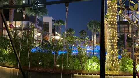 ساحة مطعم خارجية مع إضاءة ليلية ونافورة