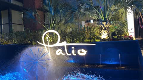 لوحة نيون باتيو ونافورة مياه بإضاءة ليلية