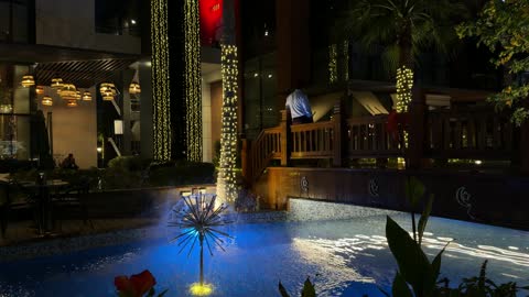 نافورة مياه خارجية مضيئة في ساحة مطعم بالليل