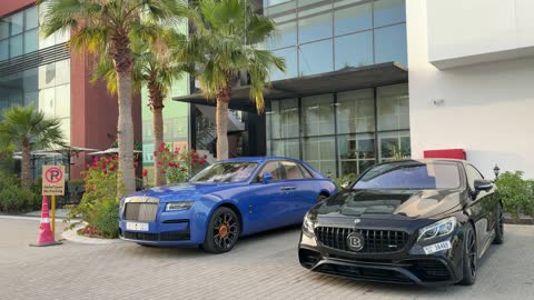 سيارات فاخرة متوقفة في دبي بمبنى حديث