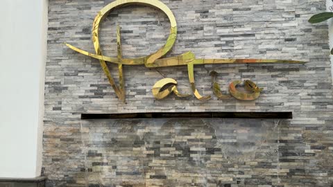 لوحة باتيو ذهبية على جدار حجري مع نافورة مياه