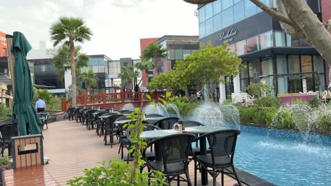 جلسات مقهى خارجية ونوافير مياه في ساحة تجارية فيديو