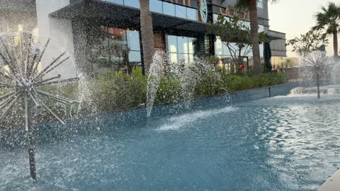 نافورة مياه كروية أمام مبنى تجاري حديث في المدينة