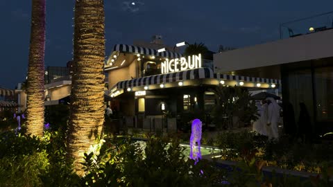 واجهة مطعم مضيئة في ساحة تجارية حضرية خارجية ليلاً