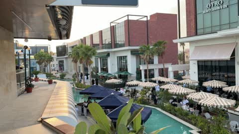 مجمع تجاري حديث يضم مقاهي خارجية وقناة مائية