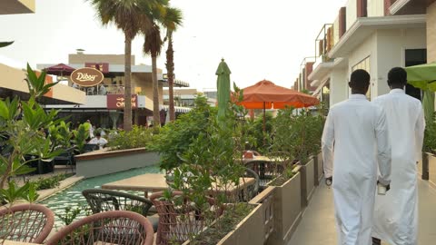 Men in Thobes Walking in Saudi Outdoor Plaza