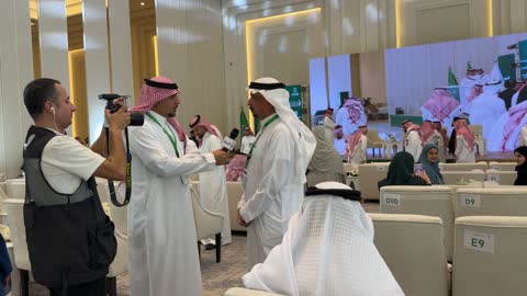 Saudi Journalist Interviewing Businessman at Conference