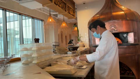 طباخ يحضر العجين في مطبخ مطعم حديث