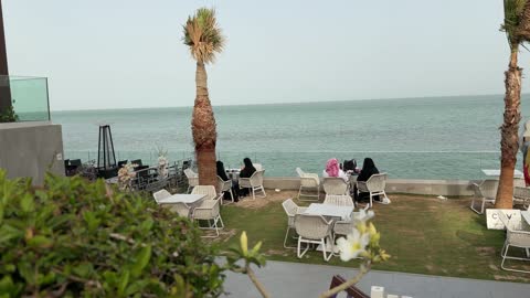 أشخاص بالزي التقليدي في مقهى مطل على البحر