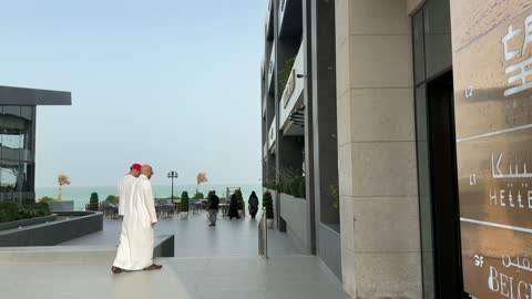 مشاة يسيرون في متنزه بحري حديث وراقي نهاراً