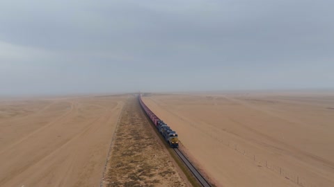 Freight Train Crossing Desert Landscape Aerial Drone Footage