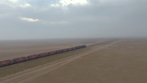 قطار شحن سار في صحراء السعودية لقطة جوية