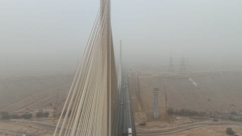 لقطات جوية لحركة المرور على جسر معلق ضخم في يوم مغبر