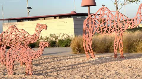 Geometric Metal Camel Sculptures in Public Park Sunset