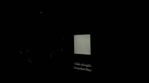 لوحة فلتر سناب شات مضيئة في حديقة ليلاً