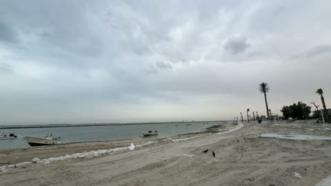 Motorboats on Sandy Beach Under Cloudy Sky