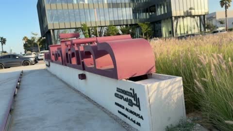 Ahmed Almousa Holding Office Sign and Modern Building