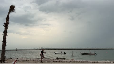 Nordic Walking Man on Coastal Beach Path Overcast Sky