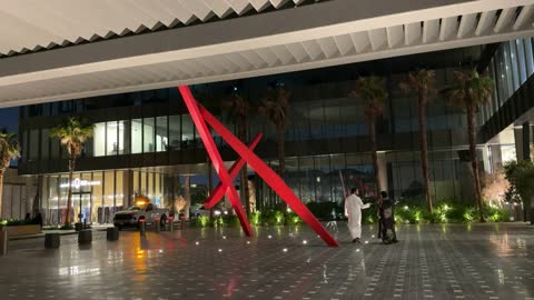 Arab Couple Walking in Modern Plaza at Night