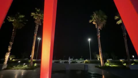 Red Sculpture Urban Plaza Night Pedestrians Walking