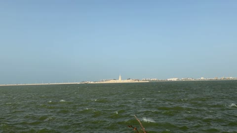 أمواج البحر المتلاطمة وأفق المدينة الساحلية في النهار
