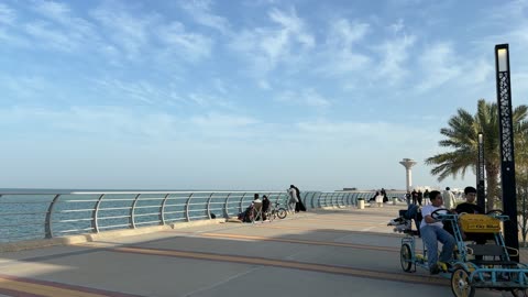 People Walking and Cycling on Seaside Promenade Daytime