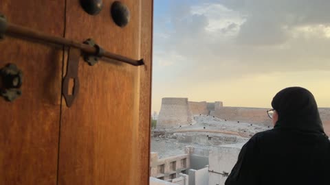 Arab Woman Looking at Ancient Fort at Sunset