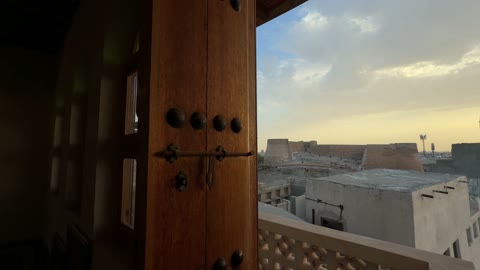 مشهد لقلعة تاريخية من خلال باب خشبي تقليدي قديم