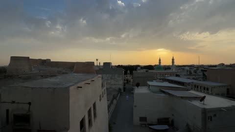 غروب الشمس فوق مدينة قديمة مع مسجد وحصن