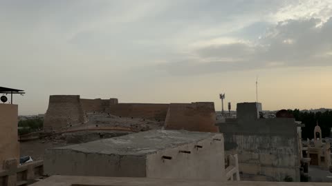 مشهد قلعة حجرية قديمة في السعودية من نافذة تقليدية