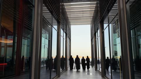 Middle Eastern Women in Abayas Walking Through Modern Corridor