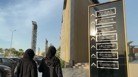 نساء بالعباءة يمشين في مركز تجاري حديث بالنهار