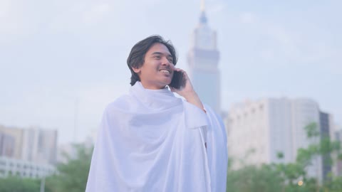 حاج بملابس الإحرام يتحدث بالهاتف في مكة المكرمة