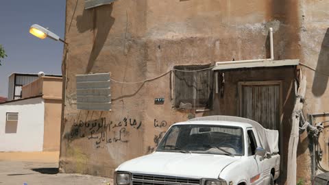 شاحنة بيك آب بيضاء أمام مبنى قديم السعودية