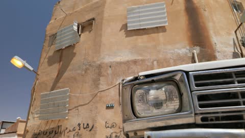 شاحنة بيضاء قديمة تالفة في بيئة حضرية متهالكة