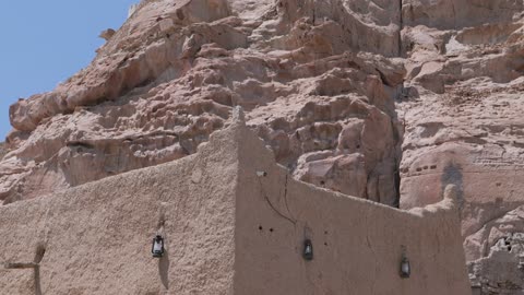 مبنى طيني قديم عند قاعدة جبل صخري