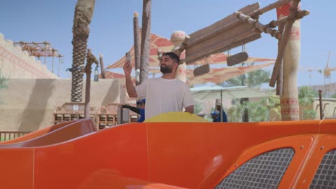 رجل يسجل بهاتفه الذكي في مدينة ملاهي ترفيهية
