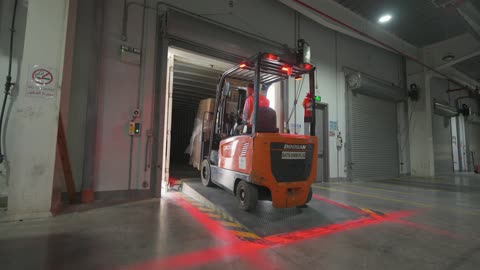 Forklift Driving into Shipping Container in Warehouse