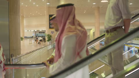 رجال سعوديون على السلم المتحرك في مطار الرياض الدولي