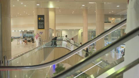 رجال سعوديون على السلم المتحرك في مطار الرياض الدولي
