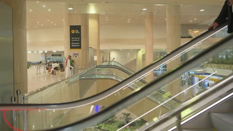 Saudi men on the escalator at Riyadh International Airport.